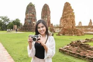 young beautiful woman traveling and taking photo at thai historical Park, Holidays and cultural tourism concept.