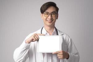 retrato de un médico de confianza masculino sobre un estudio de fondo blanco, concepto de tecnología médica y asistencia sanitaria. foto