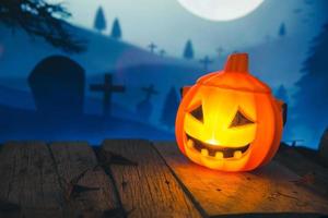 Spooky cemetery with glow halloween pumpkin photo