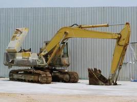 A large yellow excavator was parked in the courtyard. photo