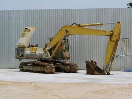 A large yellow excavator was parked in the courtyard. photo