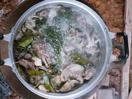 The food pot is boiling with herbs seasoning. photo