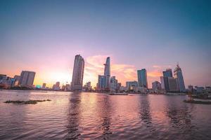 HO CHI MINH, VIETNAM - FEB 13 2022  View of Bitexco Financial Tower building, buildings, roads, Thu Thiem bridge and Saigon river in Ho Chi Minh city in sunset. High quality panorama image. photo