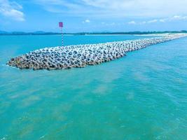 Beautiful blue skyline panoramic in Loc An Canal. Scenery landscape of fishing port with tsunami protection concrete blocks. Cityscape and boats in the sea. Loc An village near Vung Tau City. photo