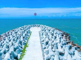 Beautiful blue skyline panoramic in Loc An Canal. Scenery landscape of fishing port with tsunami protection concrete blocks. Cityscape and boats in the sea. Loc An village near Vung Tau City. photo