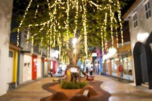 abstract blur image of night festival with a street walk and led light on tree bokeh for background photo