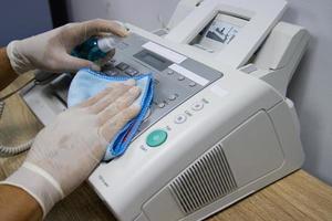 limpiar el concepto con frecuencia, concentrarse en las áreas que permiten que los patógenos se propaguen por el equipo, como los teclados o los botones de fax foto