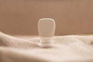lotion tube mockup isolated on brown fabric background. photo