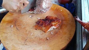 Roast duck on a wooden cutting board to prepare for slicing. Duck rice shop video