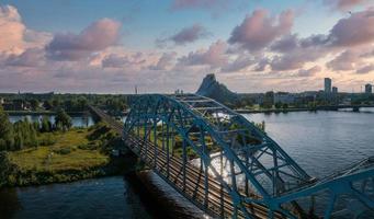 un puente sobre el río daugava en riga con un tren pasando. foto