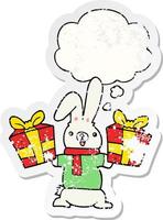 cartoon rabbit with christmas presents and thought bubble as a distressed worn sticker vector