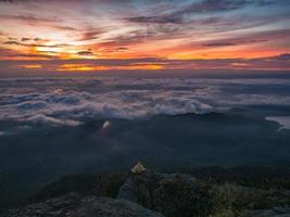 Beautiful Sunrise Sky with Sea of the mist of fog and Small Golden pagoda in the morning on Khao Luang mountain in Ramkhamhaeng National Park,Sukhothai province Thailand photo