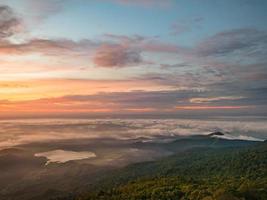 hermoso cielo de amanecer con mar de niebla y lago en forma de corazón por la mañana en la montaña khao luang en el parque nacional ramkhamhaeng, provincia de sukhothai tailandia foto
