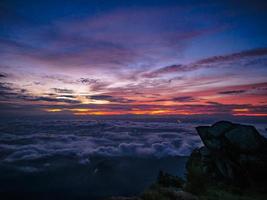 hermoso cielo del amanecer con el mar de la niebla de la mañana en la montaña khao luang en el parque nacional ramkhamhaeng, provincia de sukhothai tailandia foto