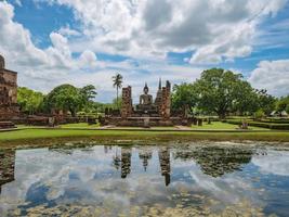 Ancient Statue reflection in the water in Wat mahathat Temple Area At sukhothai historical park,Sukhothai city Thailand photo
