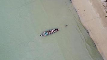 vista aérea desde drones de barcos de pesca en la orilla durante la marea baja. vista superior de muchos barcos de pesca tradicionales tailandeses de cola larga en las islas tropicales. un montón de botes de cola larga en el mar video