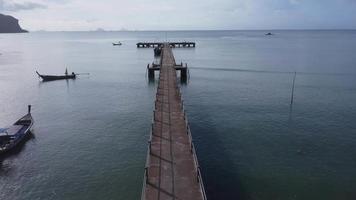 Luftaufnahme von einer Drohne eines Piers in einem tropischen Meer. Viele traditionelle thailändische Longtail-Fischerboote auf der Südinsel Thailands. video