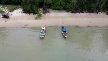 antenne visie van drones van visvangst boten in de kust gedurende laag getij. top visie van veel Thais traditioneel lange staart visvangst boten in de tropisch eilanden. een veel van lang staart boot Aan zee video