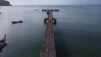 antenne visie van een dar van een pier in een tropisch zee. een veel van Thais traditioneel lange staart visvangst boten in de zuidelijk eiland van Thailand. video