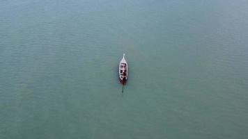 vue aérienne depuis des drones de bateaux de pêche sur le rivage à marée basse. vue de dessus de nombreux bateaux de pêche traditionnels thaïlandais à longue queue dans les îles tropicales. beaucoup de bateau à longue queue sur la mer video