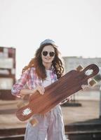 girl skateboarder holding her skateboard photo