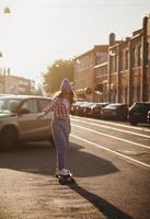 woman riding on her longboard in the city photo