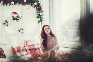 cute girl sitting on the bed waiting for Christmas photo