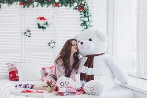 woman with teddy bear in christmas room photo