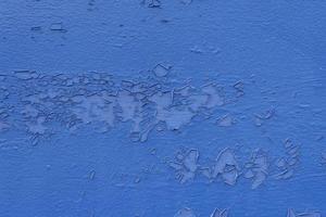 La peladura azul se desprendió de la pared de la aleta exterior, el fondo abstracto grunge sucio de la intemperie. foto