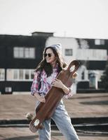 hipster cool girl in sunglasses with skateboard photo