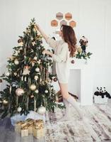 mujer decorando arbol de navidad foto
