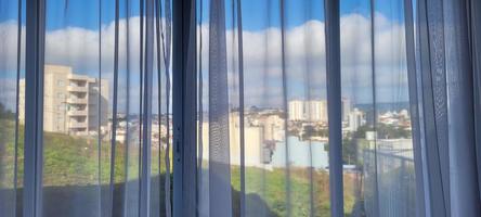 apartment window view with white curtain photo