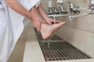 A Muslim takes ablution for prayer. Islamic religious rite photo