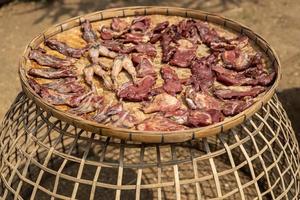 Plenty of sun-dried meat scattered on bamboo baskets to be exposed to the sun during the day. photo