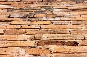 fondo borroso de una vieja pared de ladrillo marrón en un antiguo templo tailandés. foto