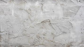 The textured background of the cement wall, plastered with a rustic simplicity with scratch marks. photo