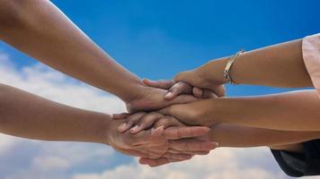 una vista de cerca de los tres niños tailandeses tomados de la mano, apilados juntos. foto