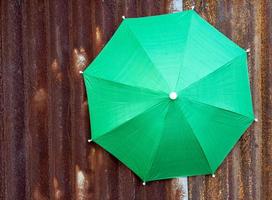 A close-up view of the top background of a large green tarpaulin umbrella. photo