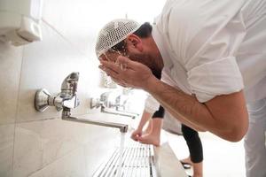 a group of Muslims take ablution for prayer. Islamic religious rite photo