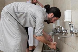 a group of Muslims take ablution for prayer. Islamic religious rite photo