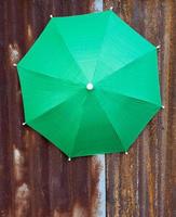 A close-up view of the top background of a large green tarpaulin umbrella. photo
