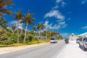 SUV driving on the road with palms on a sunny day near Cancun, Mexico photo