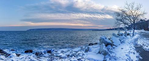 Winter landscape, sunrise, or sunset at the shore. Panoramic view photo