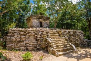 Mayan ruins in shadow of trees in jungle tropical forest Playa del Carmen, Riviera Maya, Yu atan, Mexico photo