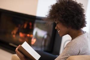 mujer negra en casa leyendo un libro foto