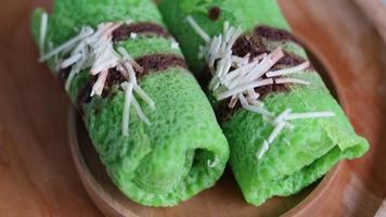 Pandan-flavored pancake rolls filled with young coconut photo