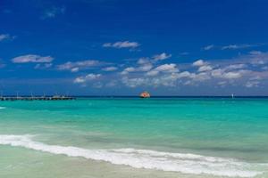 ferry naranja en el océano azul con gente nadando en playa del carmen, yukatan, méxico foto