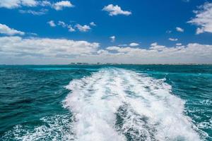 Trail of water left by a boat in the lake, travel image on a boat in Caribbean Ocean near Cancun, Yucatan, Mexico photo
