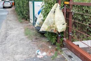 Yellow bag, fence, torn open, tattered photo