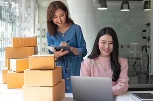 Portrait of Starting small businesses SME owners, two Asian woman check online orders Selling products working with boxs freelance work at home office, sme business online small medium enterprise photo